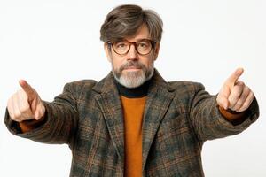 Man with glasses points forward, expressing a strong opinion in a stylish coat at a neutral backdrop photo