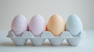 Pastel Easter eggs lying in a grey cardboard container on a white background photo