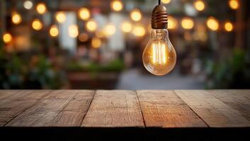 Warm light bulb hanging over an empty wooden table, creating a cozy atmosphere with blurred lights in the background photo