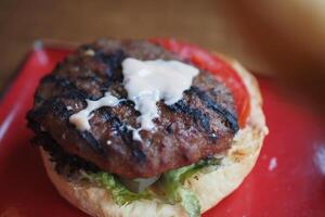 Juicy grilled hamburger with fresh vegetables on a plate photo