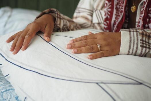 Hands resting on a soft pillow with a ring on display photo