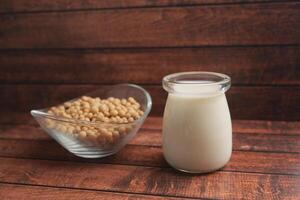 Soybeans and fresh soy milk displayed on wooden surface photo