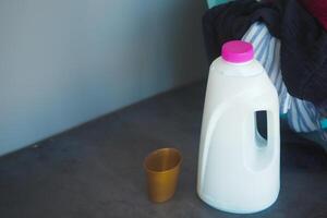 Milk jug and a cup placed on a dark table in a cozy setting photo