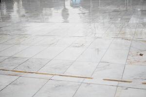 Wet marble floor reflecting light in a quiet indoor space photo