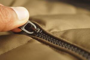 Zipper being pulled on a brown jacket in a cozy setting photo