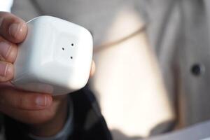 Holding a small white salt shaker in a casual dining setting photo