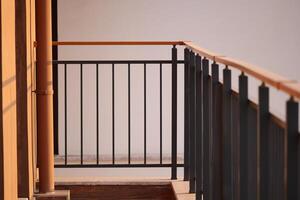 Balcony railing with sunlight shining on a wooden floor photo