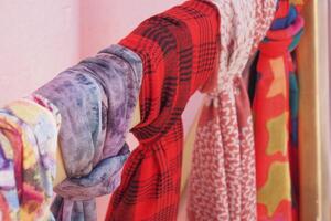 Colorful array of scarves displayed on a wooden rack in a boutique photo