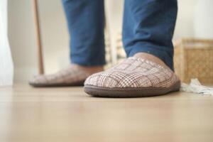 Cozy indoor slippers worn by a person in casual attire at home photo