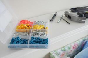 Tool organization with colorful fasteners and drill bits on shelf photo