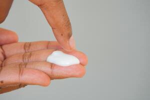 Applying moisturizer to hand with fingertip technique photo