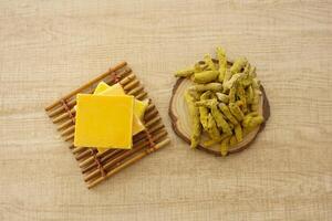Yellow turmeric roots and soap on table photo