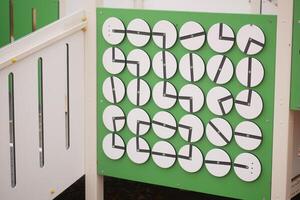 Children engage with interactive clock display in playground photo
