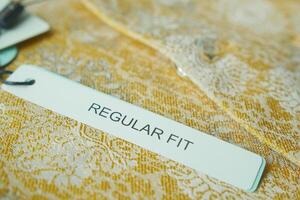 Label indicating regular fit on a lace garment displayed for sale photo