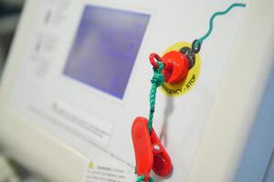 Bright red emergency stop button is prominently visible on equipment photo