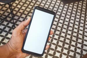 Smartphone held in hand on patterned floor in cozy indoor setting photo