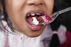 Child enjoying a colorful dessert at a celebration event photo