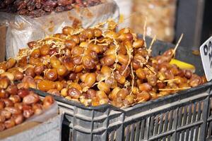 Fresh dates displayed at a market stall in a sunny outdoor setting photo