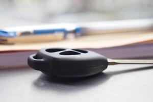 Car key and pen resting on a wooden table in a sunny room photo