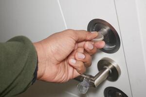 Hand inserting key into door lock in a residential setting photo
