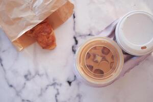 Enjoying iced coffee and croissant at a cozy table photo