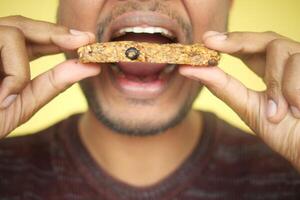 Man preparing to taste a healthy snack against a bright background photo