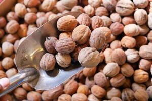 Selecting fresh walnuts at a farmers market in the autumn season photo