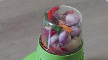 A blender with a variety of vegetables inside video