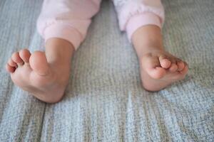 Children playing with bare feet on soft bedding in morning light photo