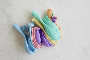 Colorful balloons stacked on a marble surface for celebration photo