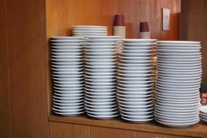 Stacked white plates neatly arranged in a restaurant kitchen area photo