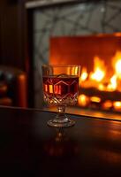 a glass of wine sitting on a table in front of a fireplace photo