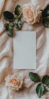 Blank white greeting card on elegant fabric with roses for romantic designs photo