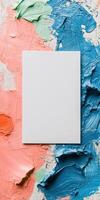Artistic flat lay with empty white card on colorful paint background for creative design photo