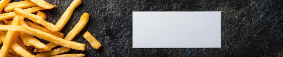 Commercial style mockup with empty white invitation and french fries on slate background photo