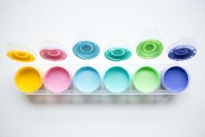 Colorful paint set with open lids displaying vibrant hues photo