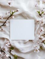 Serene floral composition with blank card on white fabric for elegant stationery design photo