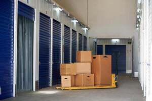 A storage unit with boxes and a hand truck photo