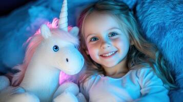A smiling girl with a unicorn plush toy in a cozy bedroom setting. photo