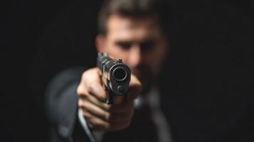A man in a suit points a handgun, creating a tense atmosphere. photo