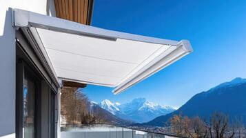 A modern balcony with an awning showcasing a stunning mountain view. photo