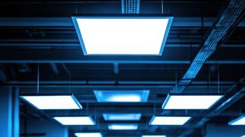 A modern ceiling with bright, square lights in a minimalistic setting. photo
