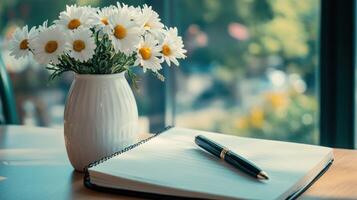 A serene workspace with a bouquet of flowers and an open notebook. photo