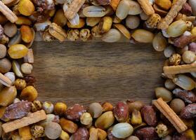 Colorful assortment of snacks arranged creatively on a wooden surface during a social gathering photo