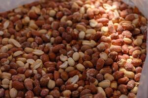 Peanut panorama showing assorted raw and roasted nuts in a rustic market setting photo