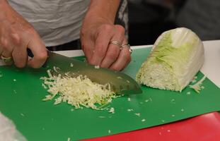 Chopping crisp cabbage at a vibrant cooking class in a bright kitchen space photo