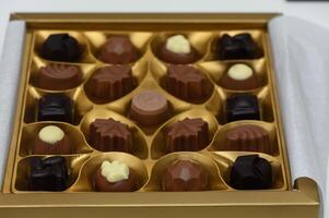 Exquisite selection of handcrafted chocolates beautifully arranged in a luxurious golden box photo