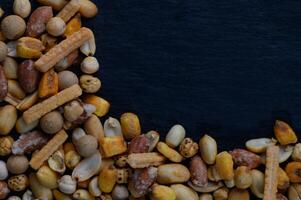 Variety of colorful snacks arranged artistically on a dark surface, showcasing texture and natural hues in an alluring composition photo