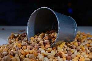 Colorful assortment of nuts and seeds spills from a tin container during a vibrant market day in autumn photo