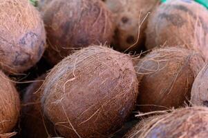 Discovering the rustic charm of fresh coconuts at a vibrant market stall on a sunny afternoon photo